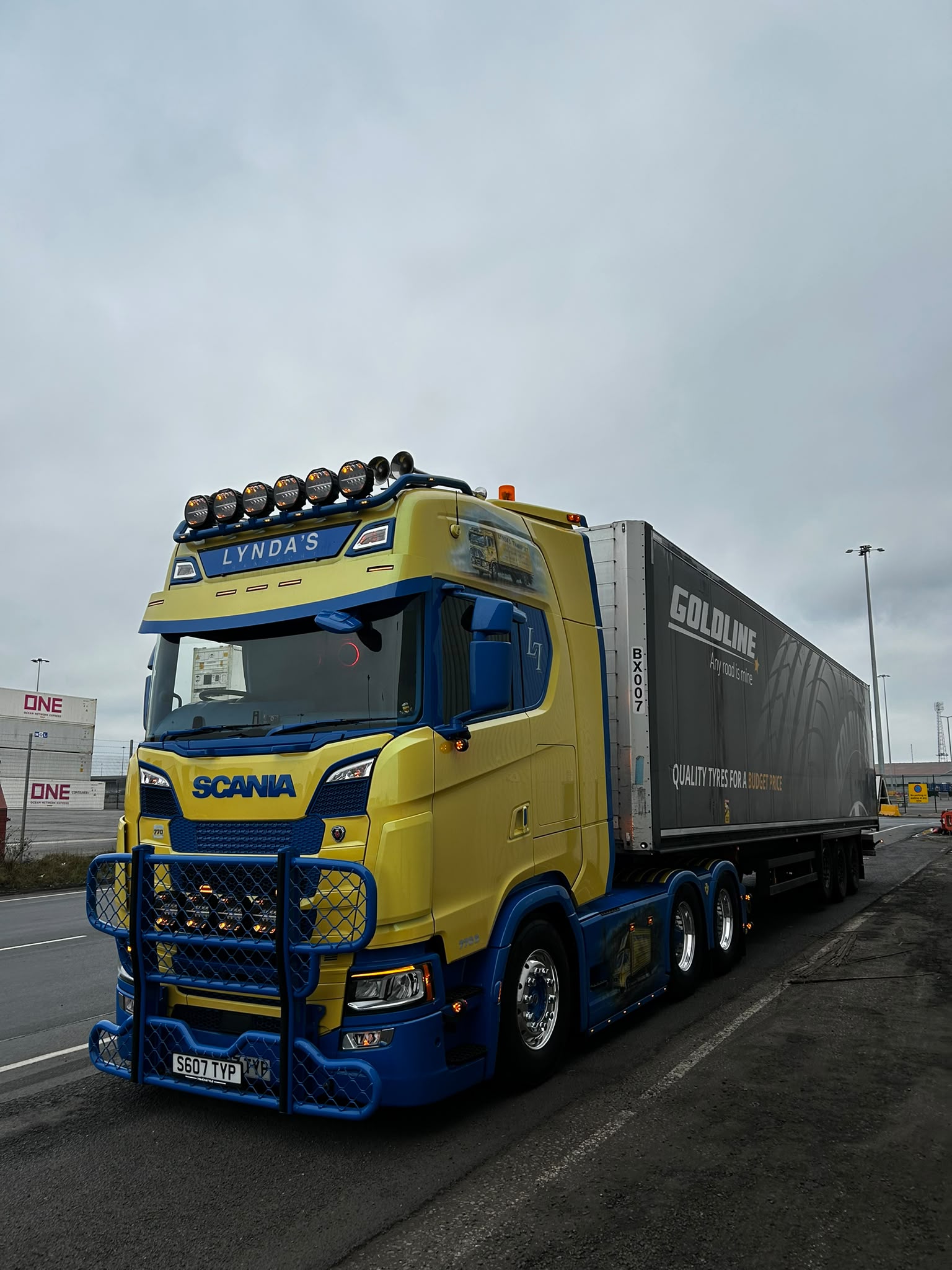 Yellow and blue Lynda's Transport Scania with a grey trailer